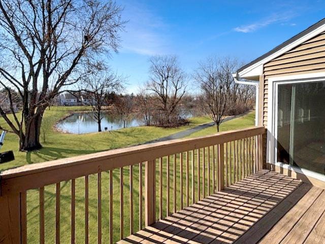 wooden deck featuring a lawn and a water view