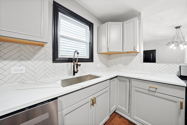 kitchen with a sink, light stone counters, decorative light fixtures, backsplash, and stainless steel dishwasher