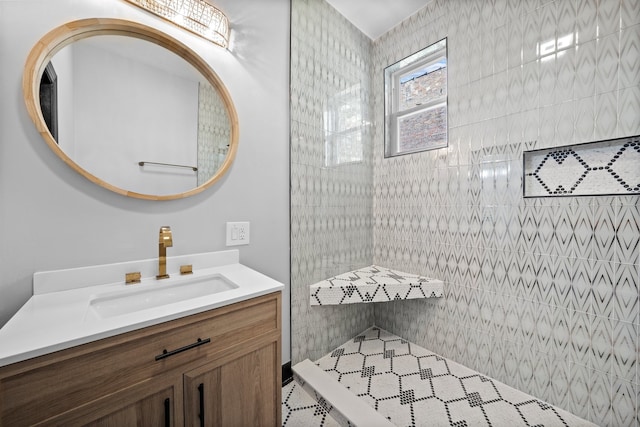 bathroom featuring tiled shower and vanity