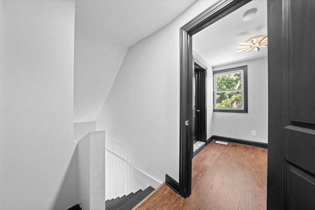 corridor featuring baseboards and wood finished floors