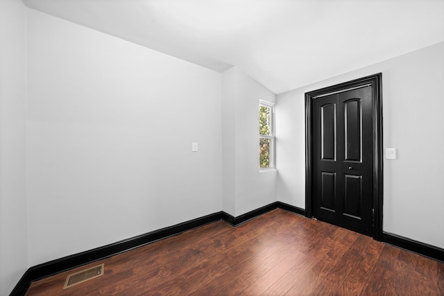 spare room with dark wood finished floors, baseboards, and visible vents