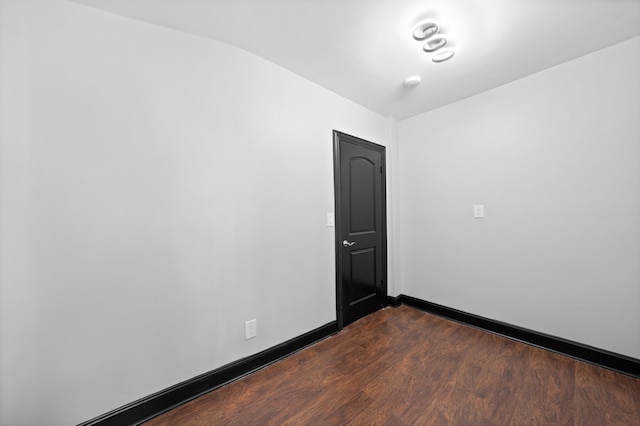 unfurnished room featuring dark wood-style floors and baseboards