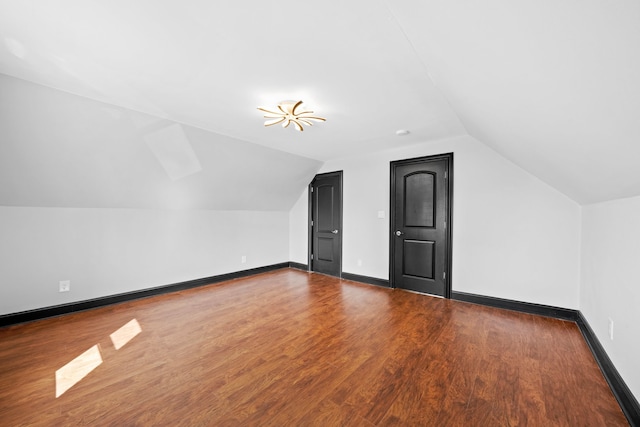 additional living space featuring lofted ceiling, wood finished floors, and baseboards