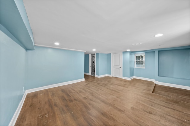 finished below grade area with recessed lighting, baseboards, and wood finished floors