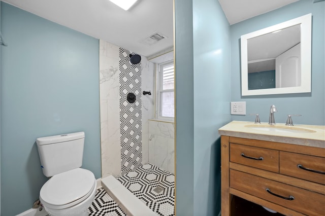 full bath featuring vanity, baseboards, visible vents, a stall shower, and toilet