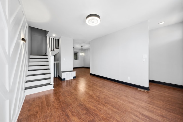 unfurnished living room featuring recessed lighting, stairs, baseboards, and wood finished floors