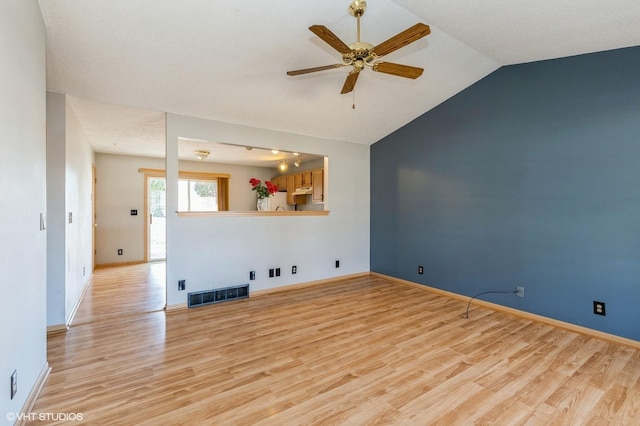 unfurnished living room with visible vents, light wood-style flooring, baseboards, lofted ceiling, and ceiling fan