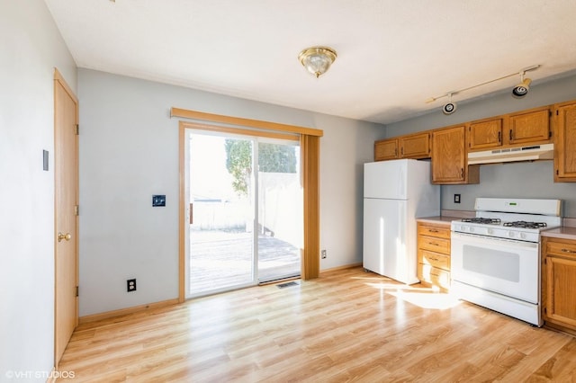 kitchen featuring baseboards, under cabinet range hood, light countertops, light wood-style flooring, and white appliances