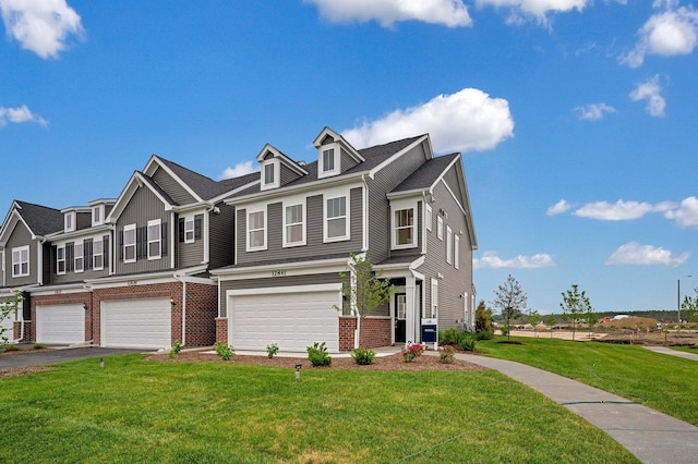 view of front of house with a front lawn, an attached garage, brick siding, and aphalt driveway