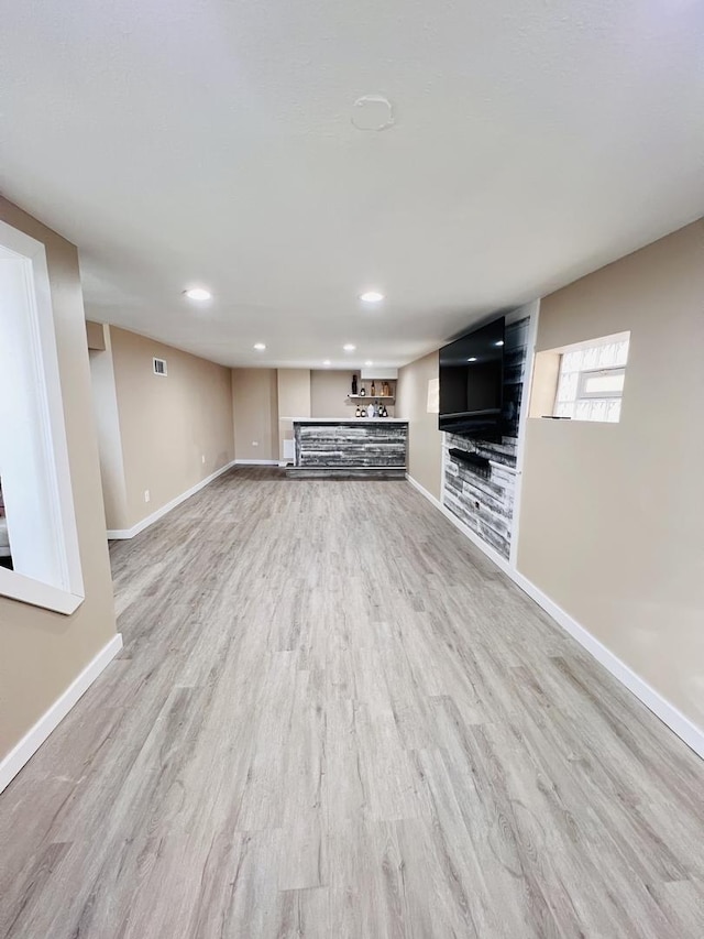 unfurnished living room with visible vents, recessed lighting, baseboards, and light wood-type flooring