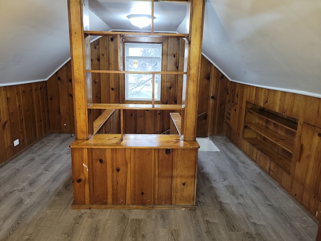 additional living space featuring wood walls, wood finished floors, and vaulted ceiling