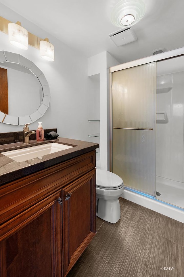 full bathroom with vanity, toilet, visible vents, and a stall shower