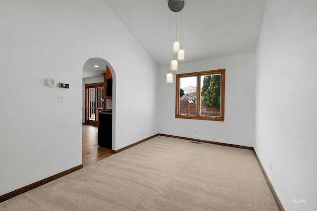 carpeted spare room featuring arched walkways, visible vents, high vaulted ceiling, and baseboards