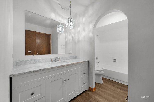 full bathroom featuring vanity, toilet, wood finished floors, and shower / washtub combination