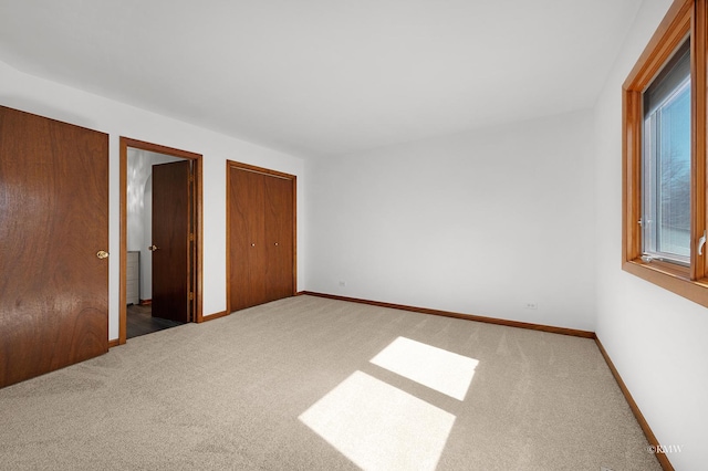 unfurnished bedroom featuring two closets, baseboards, and carpet floors