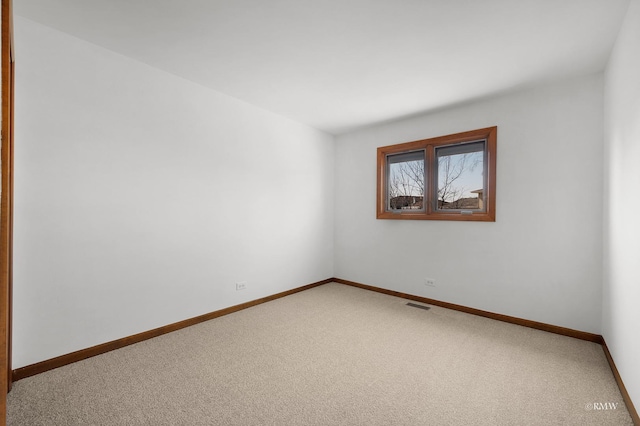 carpeted spare room with baseboards and visible vents