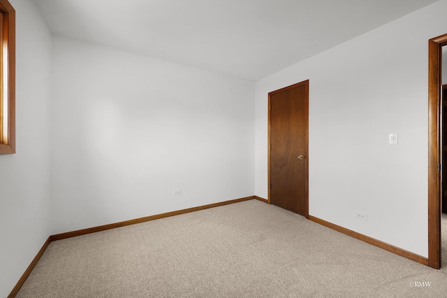 carpeted spare room featuring baseboards