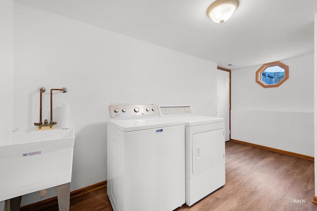 laundry room with light wood finished floors, laundry area, baseboards, and washing machine and clothes dryer