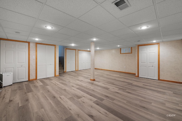 finished basement with visible vents, recessed lighting, baseboards, and wood finished floors