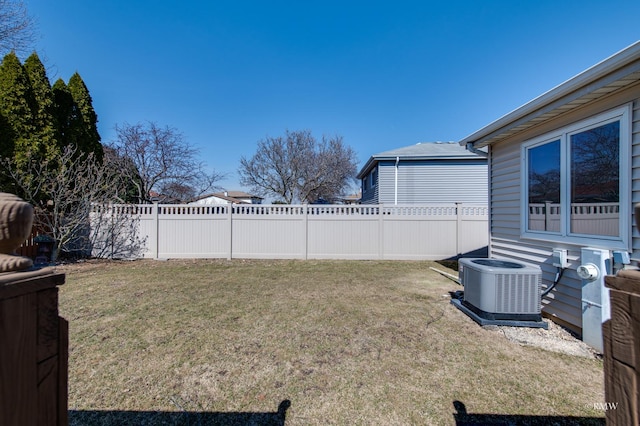 view of yard featuring central AC unit and fence