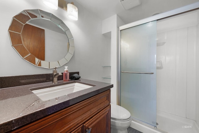 full bathroom with vanity, a shower stall, and toilet