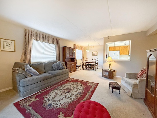 living area with baseboards and light carpet