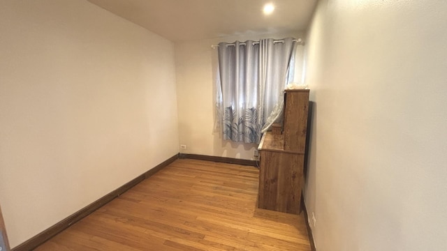 hall with light wood-type flooring and baseboards