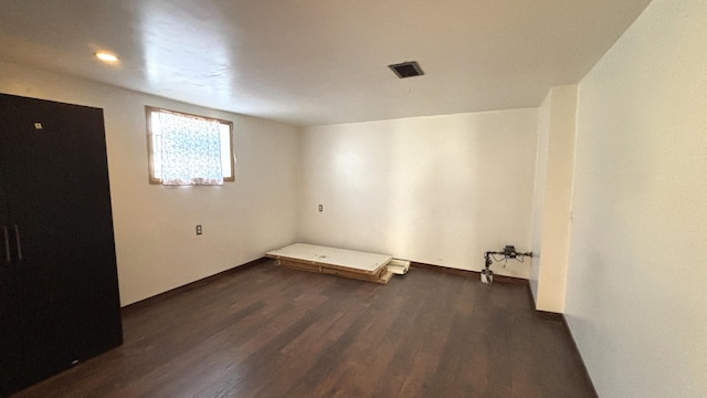 basement featuring visible vents and wood finished floors