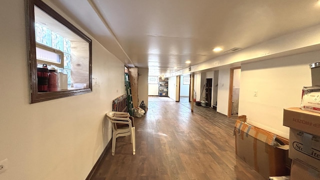 hallway with visible vents, baseboards, and wood finished floors