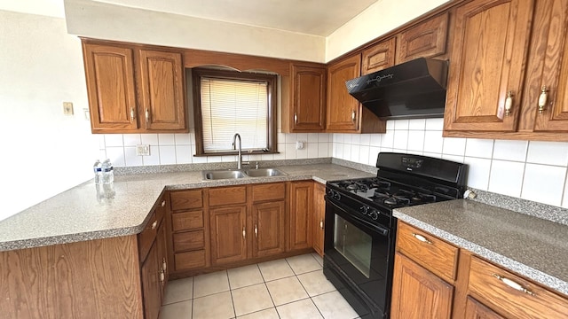 kitchen featuring under cabinet range hood, black range with gas cooktop, brown cabinetry, and a sink