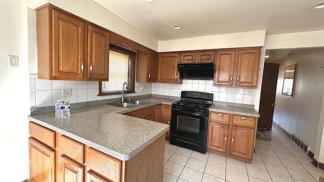 kitchen with visible vents, black gas stove, under cabinet range hood, brown cabinets, and a sink