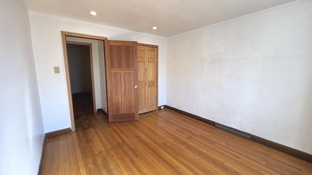 unfurnished room featuring recessed lighting, visible vents, baseboards, and hardwood / wood-style floors