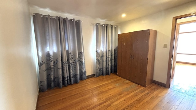 unfurnished bedroom featuring light wood-type flooring and baseboards