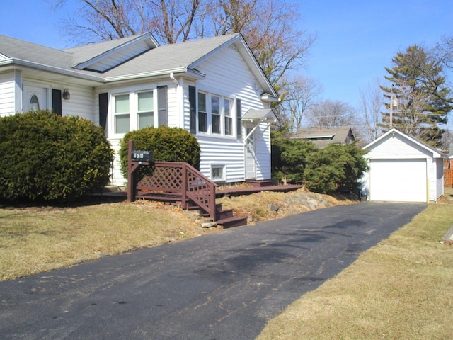 view of side of home featuring a garage and an outbuilding