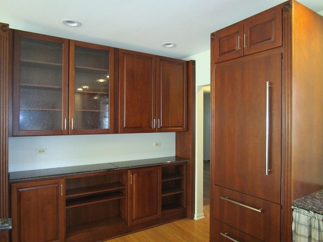 interior space with recessed lighting, glass insert cabinets, and light wood finished floors