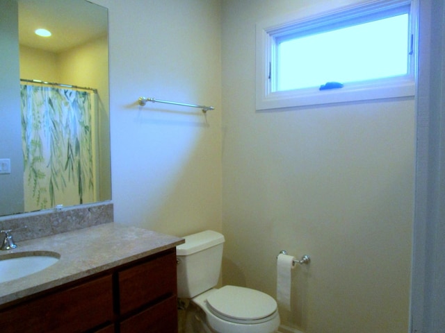 bathroom featuring vanity, a shower with shower curtain, and toilet