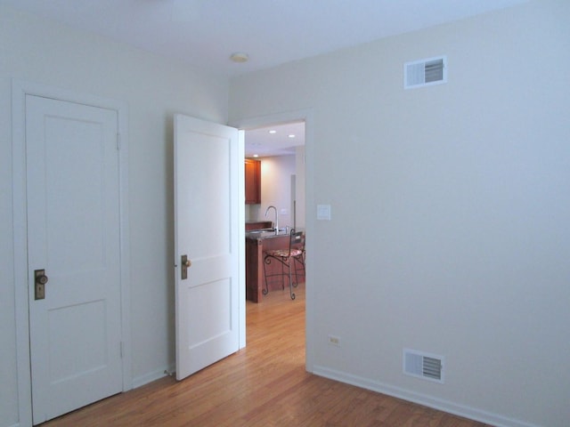 spare room with visible vents, baseboards, and light wood-style flooring