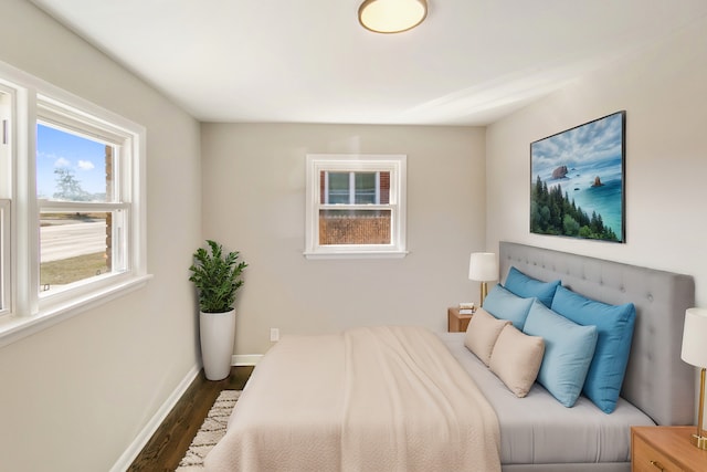 bedroom with baseboards and dark wood-style flooring