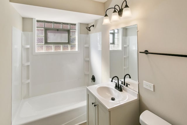 bathroom featuring a wealth of natural light, shower / washtub combination, vanity, and toilet