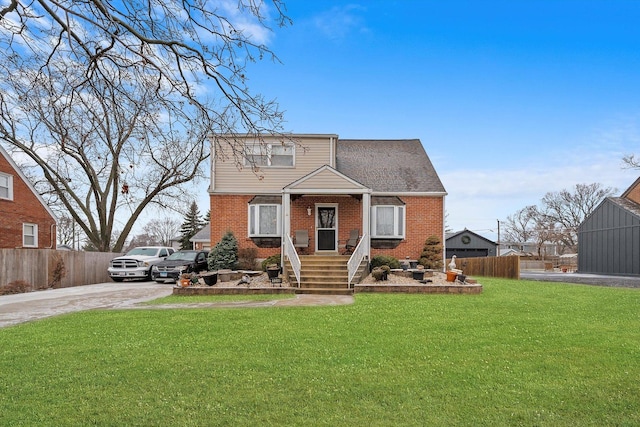 view of front of house with brick siding, roof with shingles, a front yard, and fence