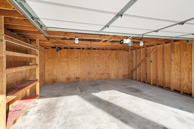 garage featuring wood walls and a garage door opener