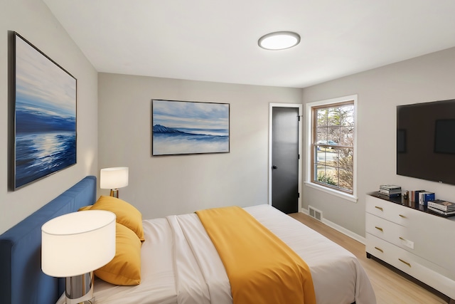 bedroom featuring light wood-style flooring, baseboards, and visible vents