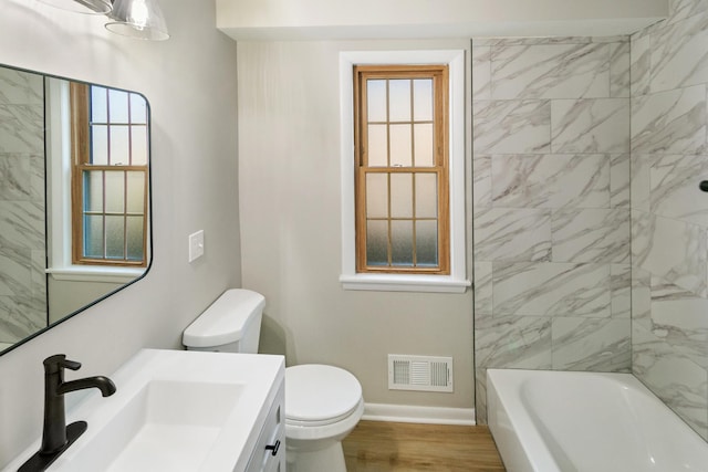 bathroom with vanity, wood finished floors, baseboards, visible vents, and toilet