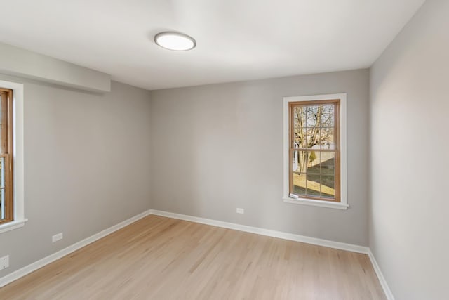 empty room with light wood-type flooring and baseboards