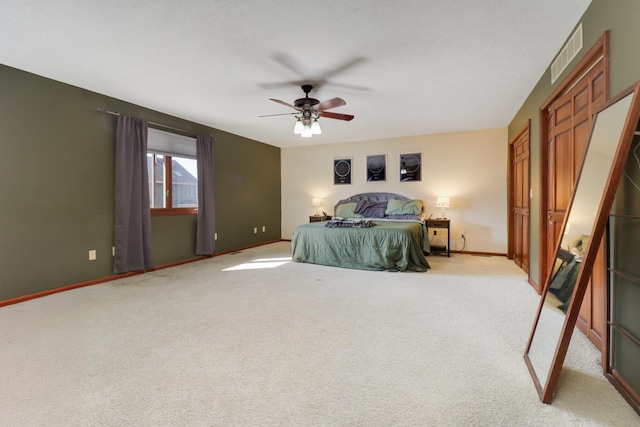 carpeted bedroom with visible vents, baseboards, and a ceiling fan