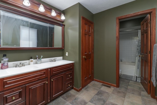 full bath featuring double vanity, toilet, baseboards, and a sink