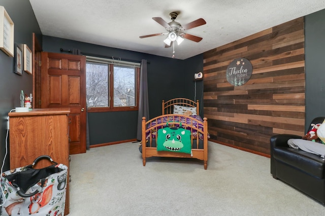 bedroom featuring ceiling fan, a textured ceiling, wood walls, and carpet floors