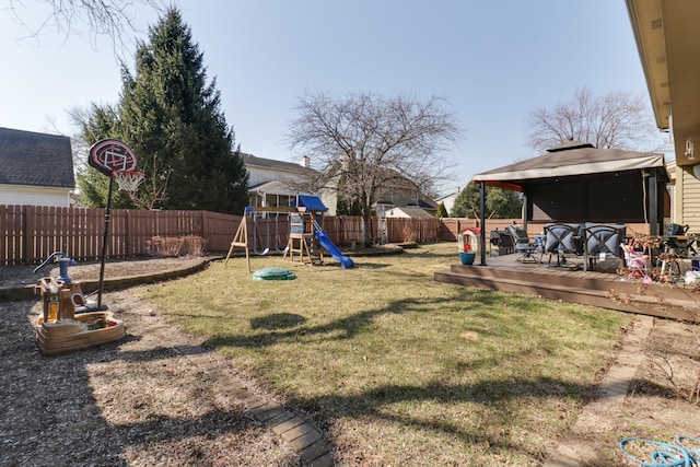 view of yard featuring a gazebo, a deck, a playground, and a fenced backyard