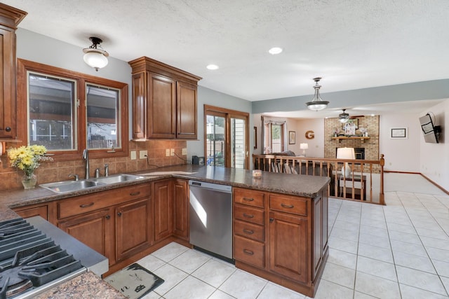 kitchen with light tile patterned floors, a peninsula, a sink, dishwasher, and brown cabinets