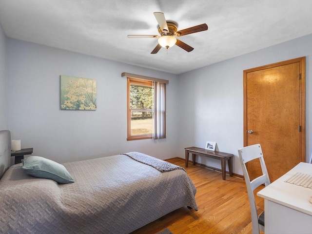 bedroom with ceiling fan, baseboards, and light wood-style floors